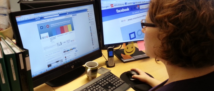 Redakteurin arbeitet am Bildschirm und editiert Facebook Seite